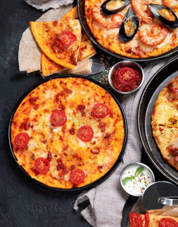 Téléchargez les photos : Assortiment de différents types de pizzas italiennes sur fond noir, vue de dessus. - en image libre de droit