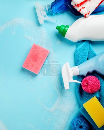Foto de Recogida de artículos de limpieza sobre fondo azul. Trabajo doméstico, concepto de servicio de limpieza. Vista superior - Imagen libre de derechos