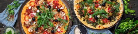 Photo for Italian pizzas with pesto and tomato sauce. Delicious vegan pizzas on black background. Top view. Panorama, banner. - Royalty Free Image