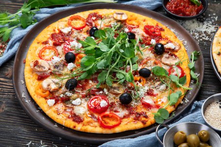 Téléchargez les photos : Pizzas italiennes au pesto et sauce tomate. Délicieuses pizzas végétaliennes sur fond noir. Vue du dessus. - en image libre de droit
