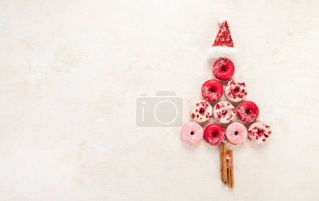 Téléchargez les photos : Arbre de Noël fait de beignets sucrés. Vue de dessus, position plate sur fond clair avec espace de copie - en image libre de droit