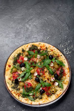 Foto de Pizza Margherita con tomates, queso, albahaca y aceitunas sobre fondo negro. Pizza vegetariana fina casera. Vista superior. Copiar espacio. - Imagen libre de derechos