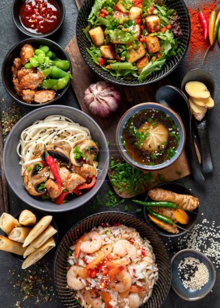 Téléchargez les photos : Fond alimentaire asiatique avec divers ingrédients sur un fond noir, vue de dessus. - en image libre de droit