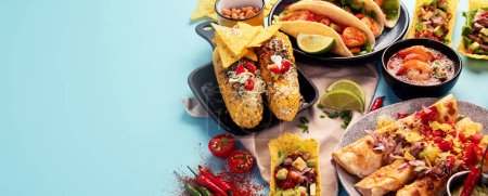 Téléchargez les photos : Cuisine mexicaine, de nombreux plats de la cuisine du Mexique sur un fond bleu. Vue de dessus. Panorama avec espace de copie. - en image libre de droit