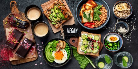 Photo for Tasty food with avocado toast, vegetables, eggs on dark background. Helthy breakfast concept. Top view, banner. - Royalty Free Image