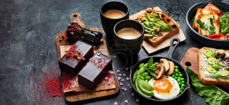 Photo for Tasty food with avocado toast, vegetables, eggs on dark background. Helthy breakfast concept. Copy space, banner, panorama. - Royalty Free Image