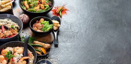Téléchargez les photos : Fond alimentaire asiatique avec divers ingrédients sur un fond noir, vue de dessus. Panorama avec espace de copie. - en image libre de droit