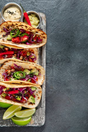 Téléchargez les photos : Tacos de rue mexicain plat de composition avec du citron vert, du poivre et de la sauce. Vue du dessus, espace de copie. - en image libre de droit