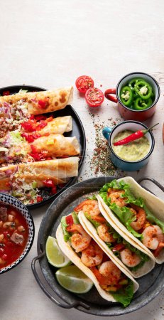 Foto de Platos tradicionales mexicanos Tacos con camarones, sopa de carne, tortillas de maíz, salsa de tomate sobre un fondo blanco. Vista superior. - Imagen libre de derechos
