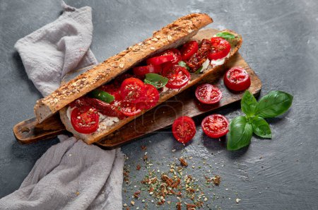 Photo for Fresh baguette with Caprese. Delicious sandwich with with tomatoes and mozzarella cheese with fresh basil leaves. Italian food conception. - Royalty Free Image