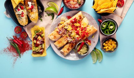 Téléchargez les photos : Cuisine mexicaine, de nombreux plats de la cuisine du Mexique sur un fond bleu. Vue de dessus. Espace de copie. - en image libre de droit