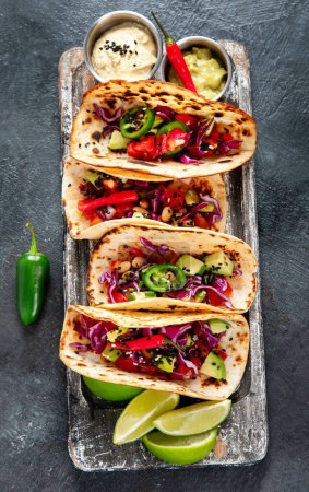 Téléchargez les photos : Tacos de rue mexicain plat de composition avec du citron vert, du poivre et de la sauce. Vue du dessus. - en image libre de droit