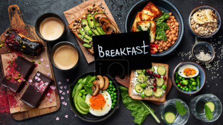 Photo for Tasty food with avocado toast, vegetables, eggs on dark background. Helthy breakfast concept. Top view. - Royalty Free Image