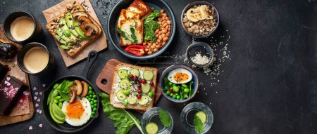 Photo for Tasty food with avocado toast, vegetables, eggs on dark background. Helthy breakfast concept. Top view, copy space, banner - Royalty Free Image