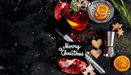 Foto de Cóctel de Navidad de invierno con granada y romero en vasos sobre fondo negro. Vista superior. - Imagen libre de derechos