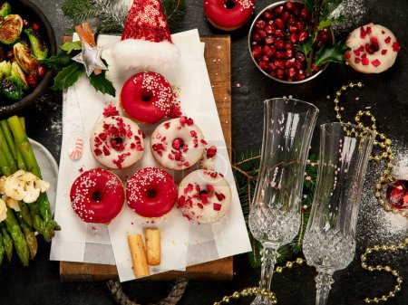 Téléchargez les photos : Jambon cuit avec des légumes et des beignets sur fond sombre. La nourriture de Noël. Vue du dessus. - en image libre de droit
