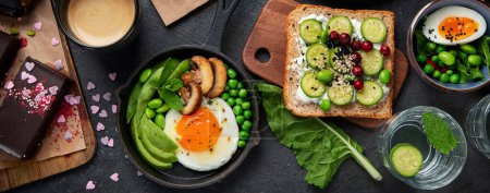 Foto de Sabrosa comida con tostadas de aguacate, verduras, huevos sobre fondo oscuro. Concepto de desayuno sutil. Vista superior. - Imagen libre de derechos