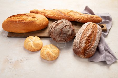 Foto de Surtido de varios deliciosos panes recién horneados sobre fondo blanco, vista superior. - Imagen libre de derechos