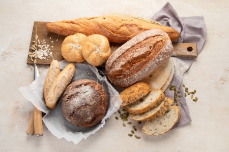 Foto de Surtido de varios deliciosos panes recién horneados sobre fondo blanco, vista superior. - Imagen libre de derechos
