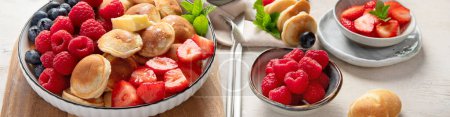 Foto de Deliciosos panqueques con arándanos, fresas y frambuesas. Desayuno dulce y sabroso sobre fondo liviano. - Imagen libre de derechos