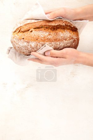 Photo for Baker or cooking chef holding fresh baked bread in hands on a light background. Concept of cooking. Copy space. - Royalty Free Image
