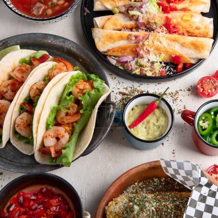 Téléchargez les photos : Plats traditionnels mexicains Tacos aux crevettes, soupe de viande, tortillas de maïs, salsa de tomates sur fond blanc. Vue du dessus. - en image libre de droit