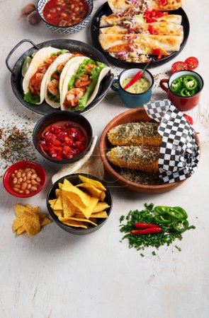 Photo for Mexican traditional dishes Tacos with shrimps, meat soup, corn tortillas , tomato salsa on a white background. Top view. Copy space. - Royalty Free Image