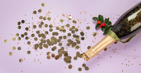 Foto de Botella de champán con confeti sobre fondo violeta. Concepto de Navidad, cumpleaños o boda. Puesta plana. - Imagen libre de derechos