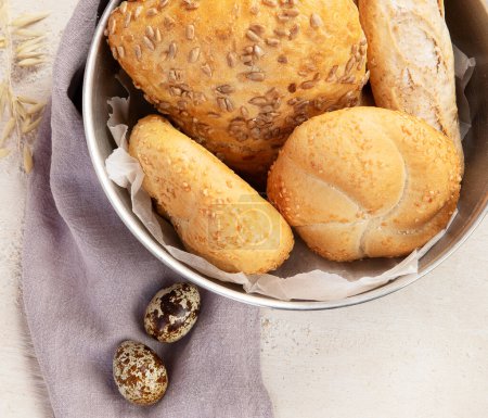 Téléchargez les photos : Boulanger ou chef cuisinier tenant du pain frais cuit dans les mains sur un fond clair. Concept de cuisine. - en image libre de droit