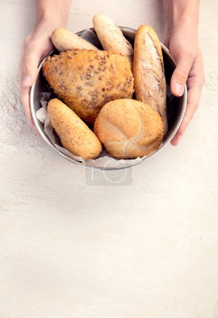 Photo for Baker or cooking chef holding fresh baked bread in hands on a light background. Concept of cooking. - Royalty Free Image