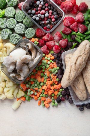 Foto de Alimentos congelados, verduras, frutas, carne, pan y pescado sobre un fondo blanco. Vista superior, espacio de copia. - Imagen libre de derechos