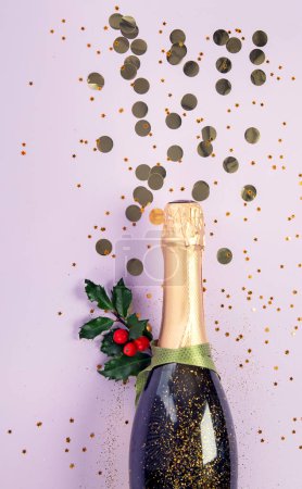 Foto de Botella de champán con confeti sobre fondo violeta. Concepto de Navidad, cumpleaños o boda. Puesta plana. - Imagen libre de derechos