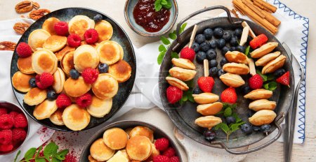 Photo for Delicious pancakes with blueberry, strawberry and raspberry. Sweet and tasty breakfast on ligt background. Top view. - Royalty Free Image