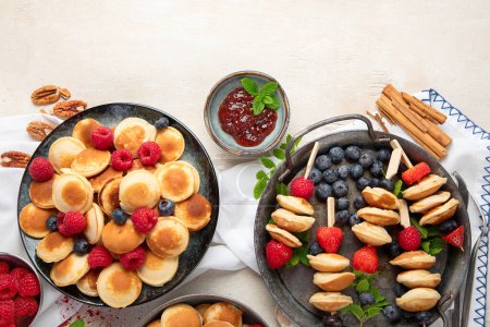Photo for Delicious pancakes with blueberry, strawberry and raspberry. Sweet and tasty breakfast on ligt background. Top view, copy space. - Royalty Free Image