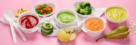 Foto de Puré de frutas y verduras en cuencos blancos con ingredientes sobre un fondo rosa. Concepto de comida para bebés. Vista superior. Panorama. - Imagen libre de derechos