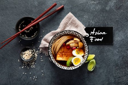 Photo for Asian soup with egg, tofu, mushrooms and onion on black background. Traditional food concept. Top view. - Royalty Free Image