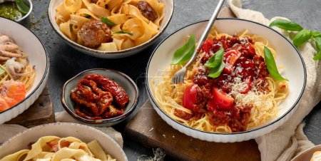 Photo for Pasta. Assortment of Italian pasta dishes, including spaghetti Bolognese, penne, tortellini, ravioli and others on a black background. Top view. - Royalty Free Image
