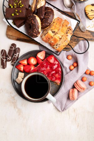 Foto de Taza de café con gofre, galletas, tarta y Dunut sobre fondo claro. Bebida caliente y postres. Vista superior, espacio de copia. - Imagen libre de derechos