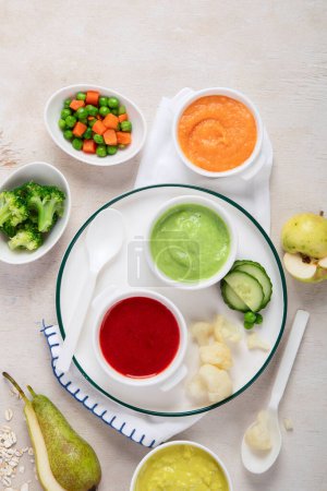Photo for Infant baby food. Bowls with vegetable fruit puree, green, orange, yellow colors - broccoli, carrots, banana, apple. - Royalty Free Image