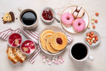 Photo for Table with various american cookies, donuts, pancakes and coffe cups on white backround. Top view. - Royalty Free Image