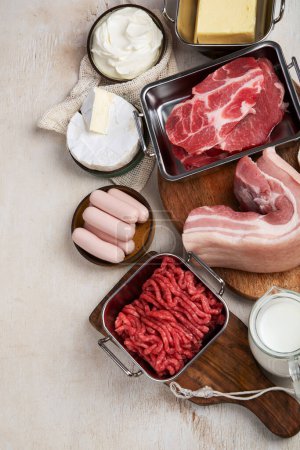Photo for Saturated fats on tables. Raw meat, sausages, cheese, butter. Bad food concept. Top view, copy space - Royalty Free Image