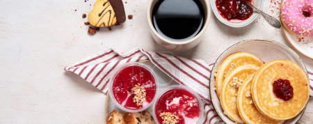 Photo for Table with various american cookies, donuts, pancakes and coffe cups on white backround. Top view. Panorama with copy space. - Royalty Free Image