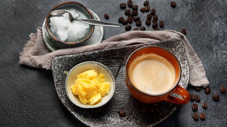 Photo for Bulletproof keto coffee. Ketogenic diet. Hot dring with coconut oil and ghee butter on dark background. Top view - Royalty Free Image