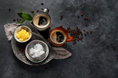 Photo for Bulletproof keto coffee. Ketogenic diet. Hot dring with coconut oil and ghee butter on dark background. Top view, copy space - Royalty Free Image