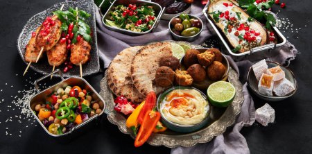 Téléchargez les photos : Moyen-Orient ou arabe différents plats sur fond noir. Savoureux concept de nourriture traditionnelle. Vue du dessus - en image libre de droit