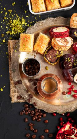 Photo for Hot tasty coffee with various pieces of turkish delight desets on a dark background. Traditional arabian food. Top view, copy space. - Royalty Free Image