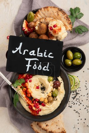 Photo for Bowl of fried falafel, pita and hummus dip. Middle Eastern cuisine snack on a light background. Top view. - Royalty Free Image