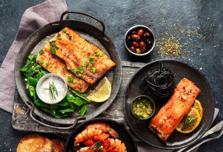 Foto de Filete de salmón a la parrilla con limón y tiras. Platos de comida de mar surtido. Concepto saludable. Vista superior - Imagen libre de derechos