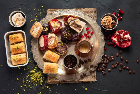 Photo for Hot tasty coffee with various pieces of turkish delight desets on a dark background. Traditional arabian food. Top view. - Royalty Free Image