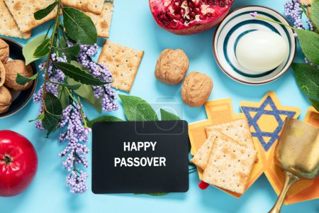 Photo for Passover celebration concept. Matzah, red kosher walnut and spring beautiful flowers on a blue background. Traditional ritual Jewish bread. - Royalty Free Image